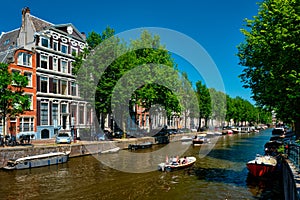 Amsterdam canal with tourist boat and old houses