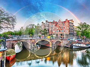 Amsterdam canal with typical dutch houses and rainbow, Holland,