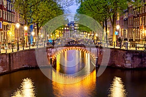 Amsterdam canal with typical dutch houses during twilight blue hour in Holland, Netherlands