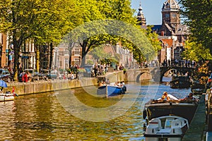 Amsterdam Canals and people enjoying spare time on their boats on a sunny day