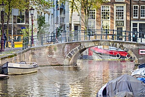 Amsterdam Cityscape With Bicycles and Bikes Along With Arched Bridge For Canal Boat Cruises in The Netherlands