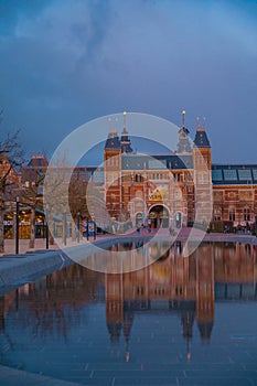 Amsterdam in a cold night during spring season. Famous national Rijks museum general view reflecting in tha water at dusk