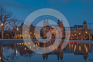 Amsterdam in a cold night during spring season. Famous national Rijks museum general view reflecting in tha water at dusk