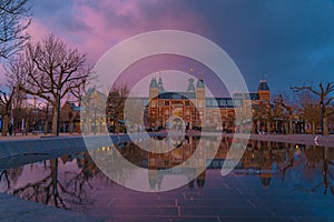 Amsterdam in a cold night during spring season. Famous national Rijks museum general view reflecting in tha water at dusk