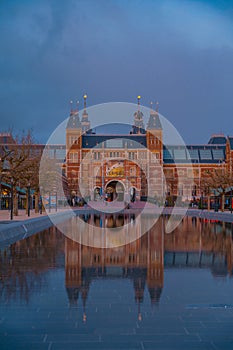 Amsterdam in a cold night during spring season. Famous national Rijks museum general view reflecting in tha water at dusk