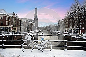 Amsterdam covered with snow with the Westerkerk in winter in the Netherlands