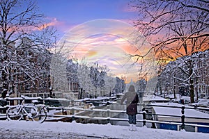 Amsterdam covered with snow in winter in the Netherlands at sun