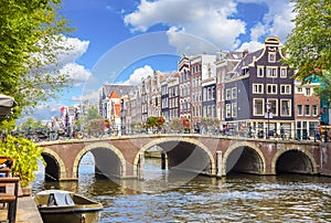 Amsterdam downtown - Amstel river, old houses and a bridge. Nice view of the famous city of Amsterdam. Travel to Europe