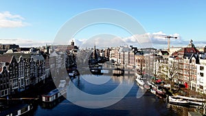 Amsterdam flying over the river Amstel in the city center towards the Munttoren and Muntplein in The Netherlands on a