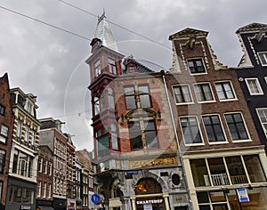 Amsterdam, Holland, August 2019. Rainy day in the old town. Among the typical little houses, a corner with a red bay window