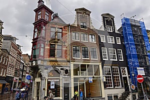 Amsterdam, Holland, August 2019. Rainy day in the old town. Among the typical little houses, a corner with a red bay window