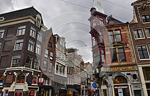 Amsterdam, Holland, August 2019. Rainy day in the old town. Among the typical little houses, a corner with a red bay window