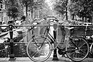 Amsterdam, Holland, May 12 2018: Old bicycle parked on a canal bridge in Amsterdam