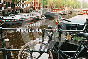 Amsterdam, Holland, May 12 2018: Old bicycle parked on a canal bridge in Amsterdam