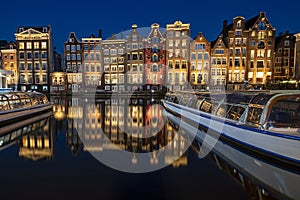 Amsterdam houses along the Damrak in Netherlands at night
