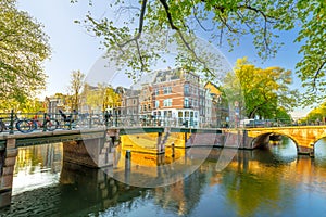 Amsterdam in the morning sun. Traditional old houses and bridges of Amsterdam. Beautiful morning in Amsterdam