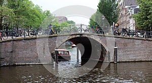 Amsterdam, The Netherlands, city canals, boats, bridges and streets. Unique beautiful and wild European city.