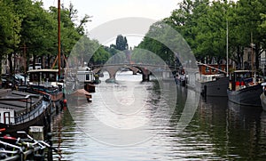 Amsterdam, The Netherlands, city canals, boats, bridges and streets. Unique beautiful and wild European city.