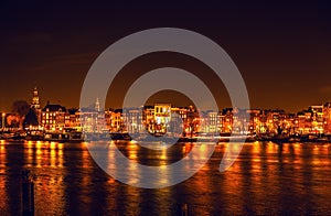 AMSTERDAM, NETHERLANDS - JANUARY 1, 2016: General view on night canal in center of Amsterdam from bridge near museum Nemo. On Jan