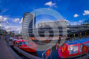 AMSTERDAM, NETHERLANDS, MARCH, 10 2018: Outdoor view of red excursion boat or cruise ship on Amsterdam water canal in