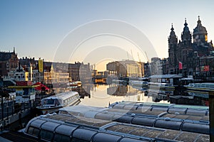 Amsterdam, Netherlands - November 9, 2019: Buildings and house boats along canal during an early autumn fall morning in the