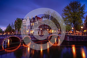 Amsterdam by night with floating boats on the river canal , evening time , travelling to Netherlands