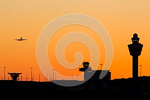 Amsterdam Schiphol airport control tower with an orange sunset