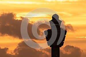 Amsterdam Schiphol International Airport control tower with a plane landing in the background during sunset