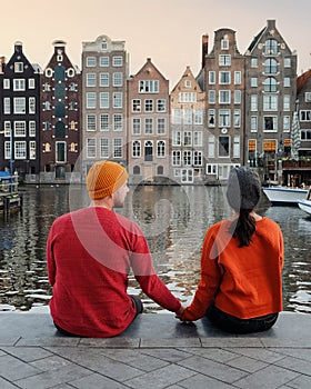 Amsterdam during sunset, happy couple man and woman during sunset at the canals during a citytrip