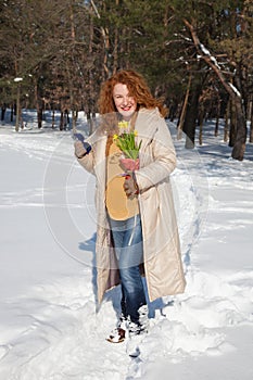 Amused pretty woman walking along snowy footpath