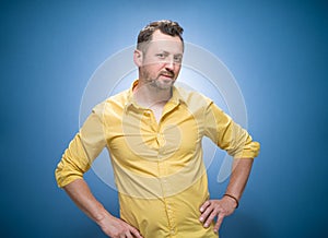 Amused thoughts young man thinking. Portrait of inspired guy over blue background, dresses in yellow shirt