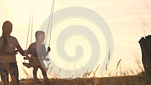 Amusement park dream concept. Happy girl swinging on a swing in the park at sunset. child plays with wooden swing