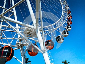 Amusement park. ferris wheel made of white metal. a huge wheel with booths for tourists in white and red. high wheel for people to