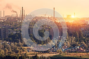 Amusement park with Ferris wheel and steel mill