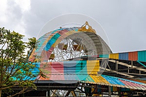 Amusement park old giant wheel colorful tin roof during heavy rain