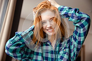 Amusing funny girl in checkered shirt with tousled red hair