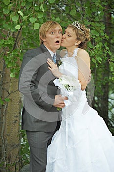 Amusing groom and bride kiss secretly