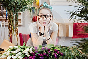 Amusing woman florist making funny face standing in flower shop