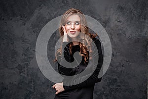 Amusing woman with long curly hair making funny duck face