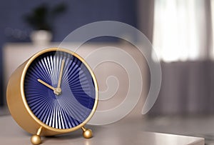 Analog alarm clock on table in living room