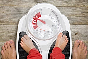 Analog bathroom scale indicating child obesity photo