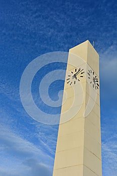 Analog clock tower in public park with blue sky background