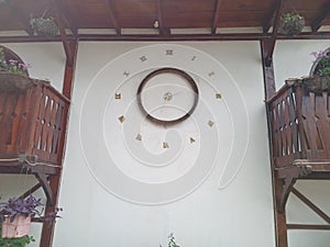 an analog clock on the white wall of the house