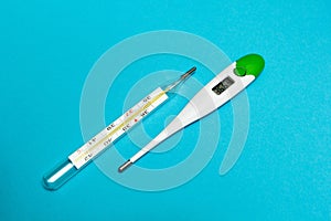 Analog and digital thermometer on a blue background. The temperature of 36.6 C