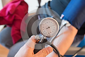 Analog sphygmomanometer in the foreground detects human high blood pressure. Hypertension concept