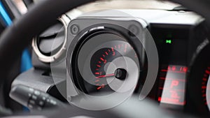 analog tachometer in a modern car with red arrows and numbers