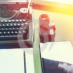 Analog Typewriter, Digital Tablet And Film Camera On The Green Table, Top View with Sunshine. Journalism Writing Concept