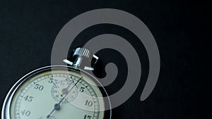 Analogue metal stopwatch on the black background