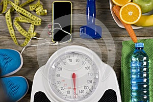 Analogue weight scale, gym object and healthy fruits on wooden background, healthy lifestyle concept