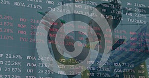 Analyst annotating transparent board in office, with green marker and financial tickers, copy space